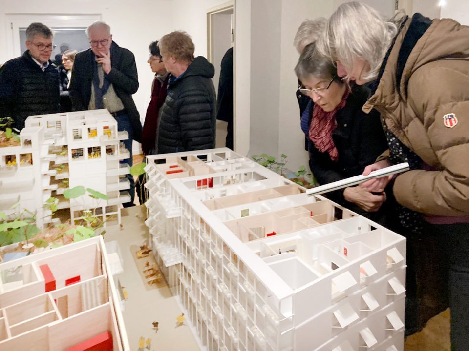 Menschen stehen um ein bauliches Modell bei Veranstaltung in Stuttgart-Rot